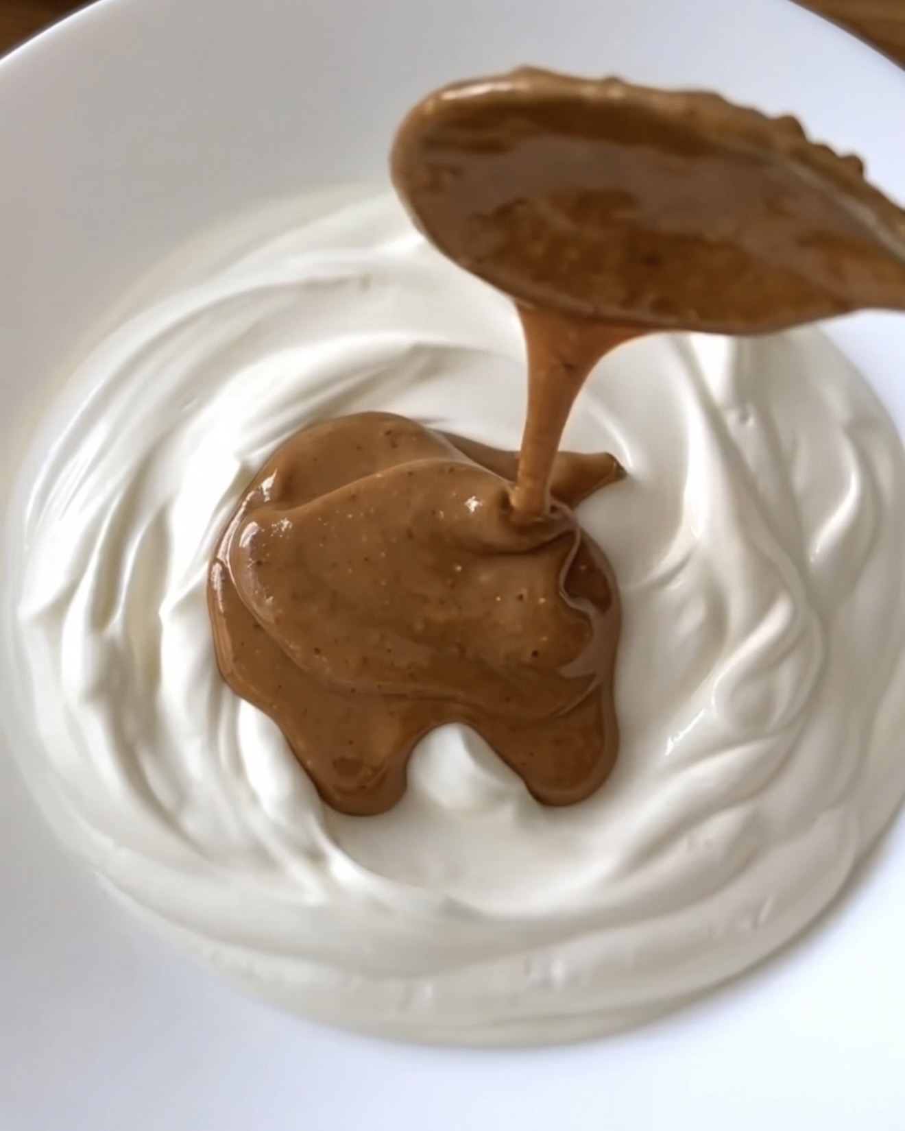 Jordnøddesmør dryppet i cremet græsk yoghurt til Ube Nolia frosne ube yoghurtbidder