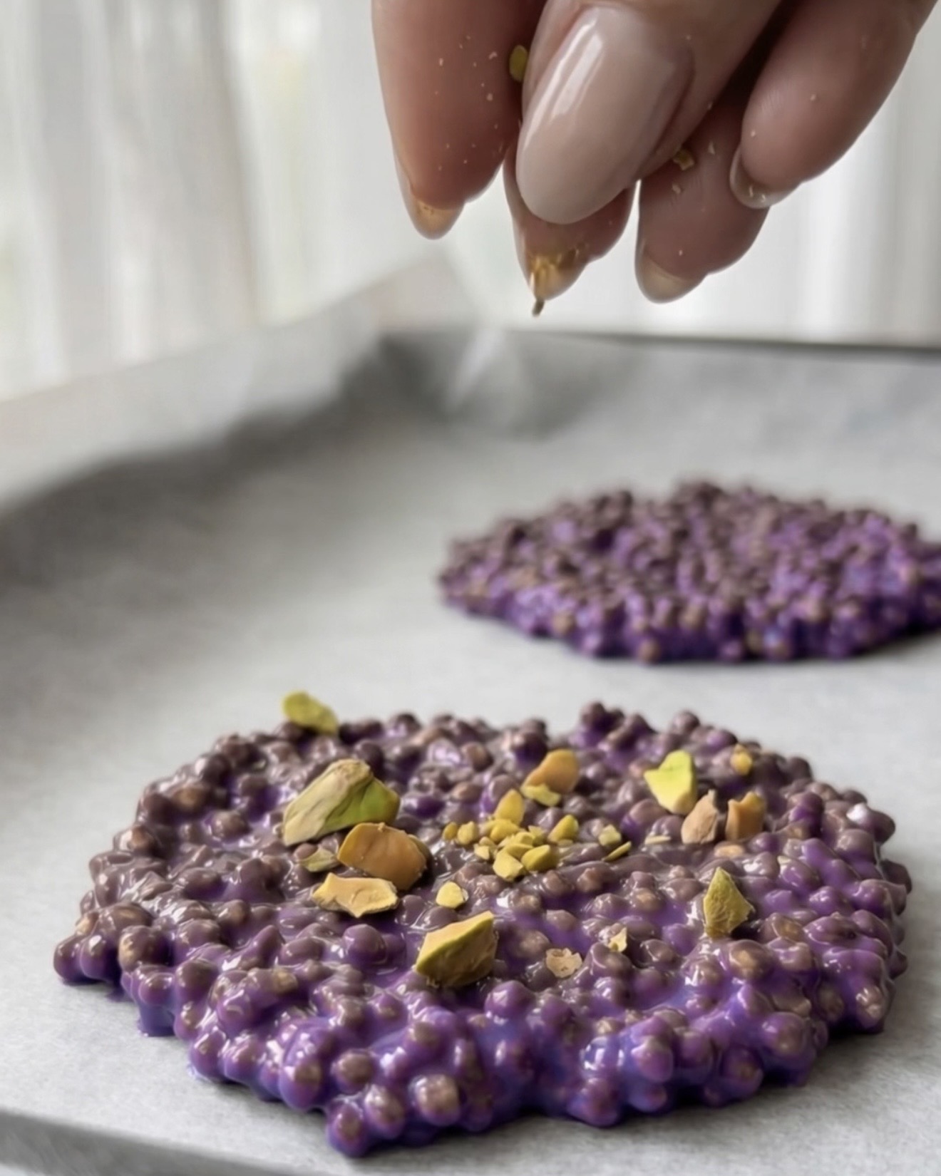 Knuste pistacienødder topper lilla ube quinoa bites fra Ube Nolia
