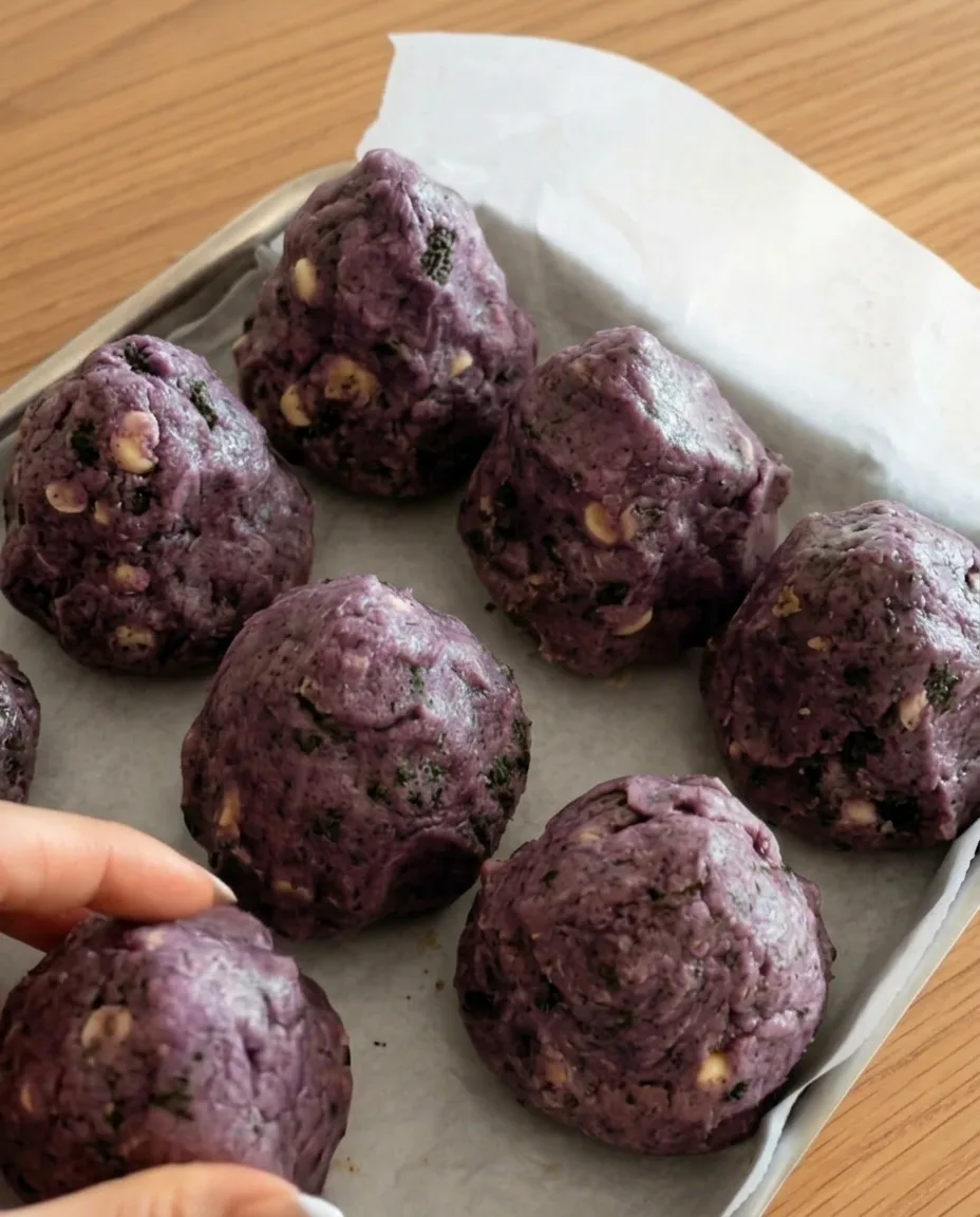 Lilla ube Oreo cookie dejkugler på bagepapir klar til at fryse til New York-stil tykke cookies