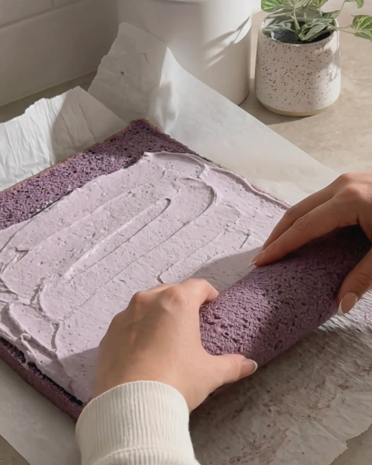 Smører ube flødeskum på den lilla chiffonkage og ruller den op af Ube Nolia