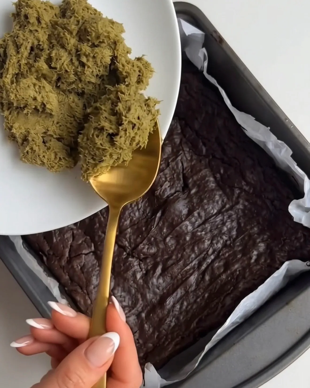 Pistacie kataifi fyld skovles over den bagte browniebund til Ube Dubai chokolade brownie bars af Ube Nolia